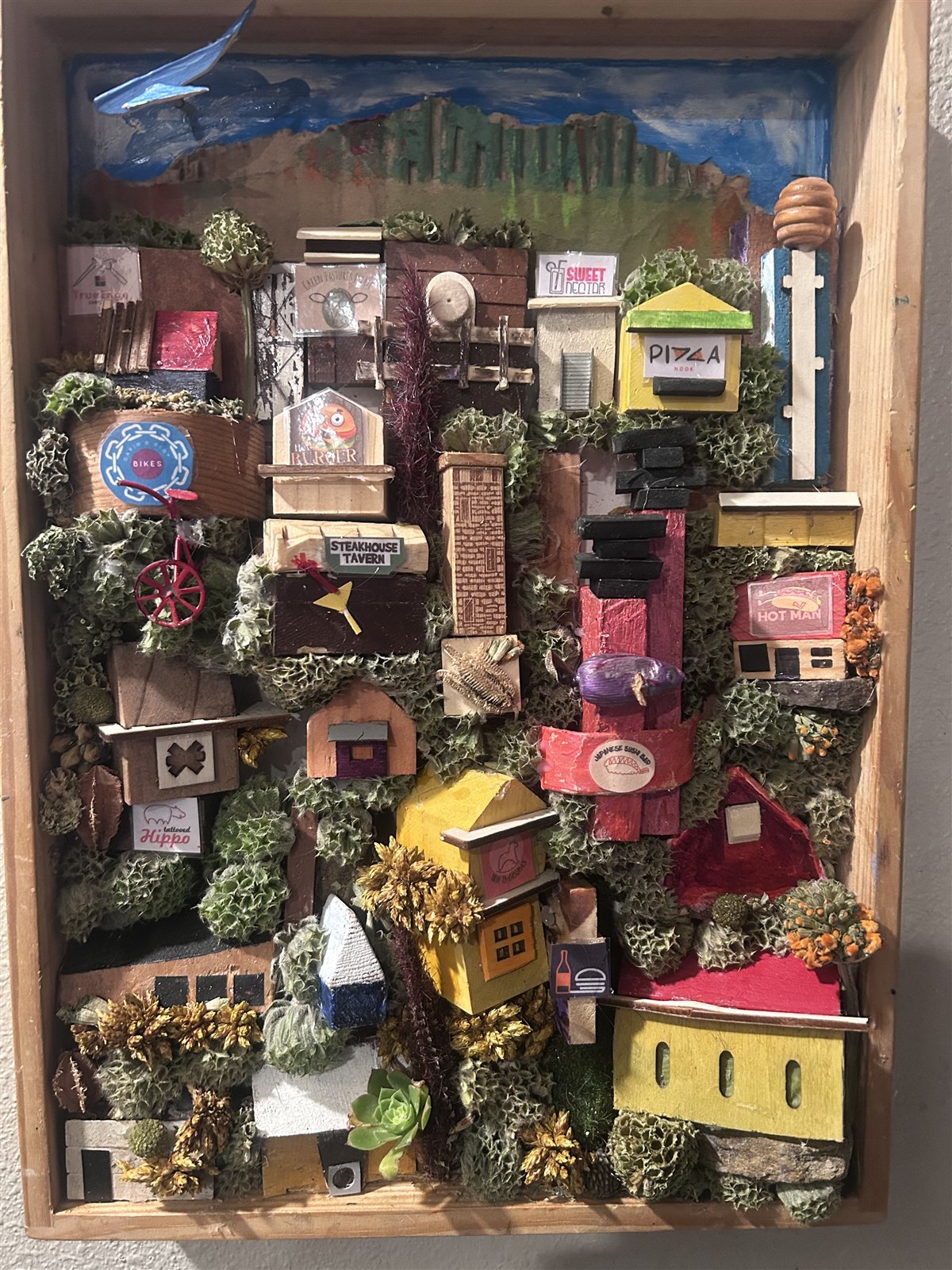 Miniature town scene built inside a wooden shadow box